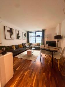 uma sala de estar com um sofá e uma mesa em Spacious One Bed Apartment Near Canary Wharf with SofaBed em Londres
