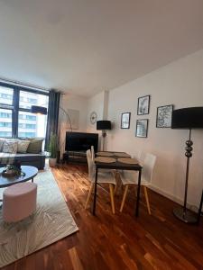 a living room with a table and a couch at NEW Spacious One Bed Apartment Near Canary Wharf in London