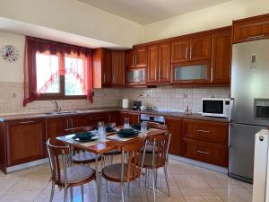 a kitchen with wooden cabinets and a table with chairs at Luna's Summer House in Kremasti