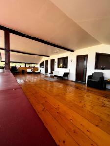 un ampio soggiorno con pavimento e mobili in legno di Vila Legrand a Baziaş
