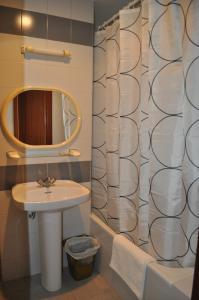 baño con lavabo y cortina de ducha en Hostal La Tablada, en Navaleno