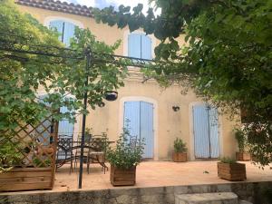 a patio with blue doors and a table and chairs at Studio L Oustaou in Marseille