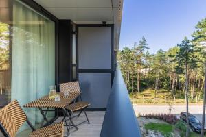 a balcony with a table and chairs and a window at Shellter Suita Flora by Renters Prestige in Rogowo