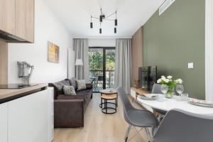 a kitchen and living room with a table and chairs at Shellter Suita Flora by Renters Prestige in Rogowo