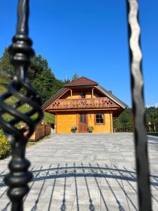 ein Gebäude mit einem Zaun davor in der Unterkunft Hiška Erika - Wood House Erika in Šoštanj