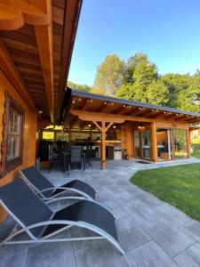 un patio al aire libre con sillas y techo de madera en Hiška Erika - Wood House Erika, en Šoštanj