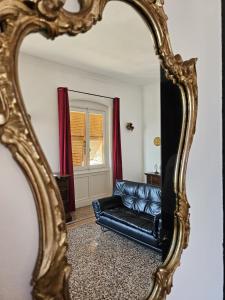 a mirror in a living room with a black leather couch at Gropallo Palace Apartments - 4 Dreams 4 You - Pieno centro - Palazzo Nobiliare Storico in Genoa