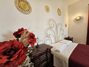 a bedroom with a bed and a vase of flowers at Gropallo Palace Apartments - 4 Dreams 4 You - Pieno centro - Palazzo Nobiliare Storico in Genoa