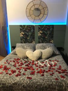 ein Bett mit einem Strauß roter Rosen darauf in der Unterkunft Une Pause Douceur - Suite Orchidée in Eyguières