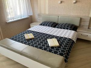 1 dormitorio con 1 cama con 2 almohadas en Viesu Nams Dzirkaļi, en Ventspils