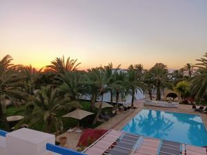 vista para a piscina num resort com palmeiras em Le Patio de Mezraya em Mezraya
