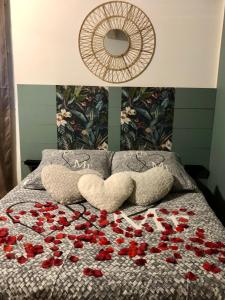 ein Bett mit roten Rosen und einem Spiegel in der Unterkunft Une Pause Douceur - Suite Orchidée in Eyguières