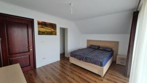 - une chambre avec un lit et du parquet dans l'établissement Casa Elisabeta, à Bilca