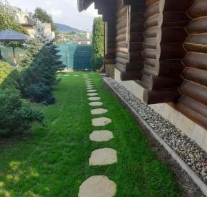 a garden with rocks on the grass next to a house at Chata Zemra in Nitrianske Rudno