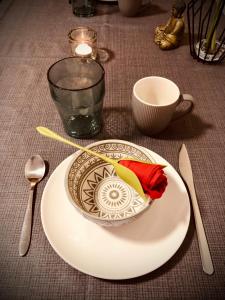 un plato con un tazón en una mesa con una vela en Une Pause Douceur - Suite Orchidée, en Eyguières