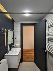 a bathroom with a white sink and a black door at Milky Way in Stepantsminda