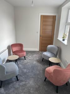 una sala de espera con sillas, mesas y una puerta en Castle gate lodge en Derry