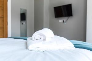 a pile of towels sitting on top of a bed at Castle gate lodge in Derry Londonderry