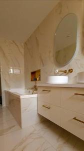 a white bathroom with a sink and a mirror at Luxury apartment with sea view in Marseille