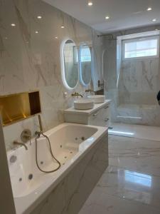 a white bathroom with a tub and a sink at Luxury apartment with sea view in Marseille