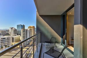 d'un balcon avec deux chaises et une vue sur la ville. dans l'établissement Elegant apartment in the City, au Cap