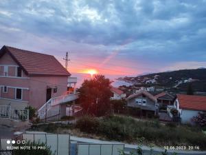 un coucher de soleil dans un quartier résidentiel avec des maisons dans l'établissement Дом для семейного отдыха в Утехе, Черногория, à Utjeha-Bušat