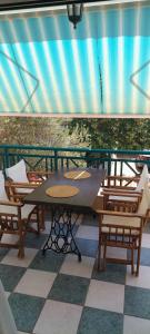una mesa y sillas en un patio con techo en The house of olives en Kallithea Halkidikis