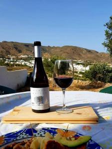 a bottle of wine and a glass on a table at Níjar has been described as one of the most picturesque towns in the whole of Spain. A visit to Níjar guarantees the traveller a flavour of the ‘real’ Andalusia without the need to overspend on the trip. in Níjar