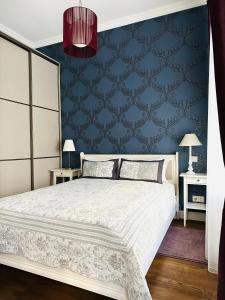 a bedroom with a bed and a blue wall at Vilnius street apartment in Vilnius