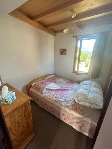 une petite chambre avec un lit et une fenêtre dans l'établissement Appartement Morzine, deux pièces, mezzanine, 4 personnes, à Morzine