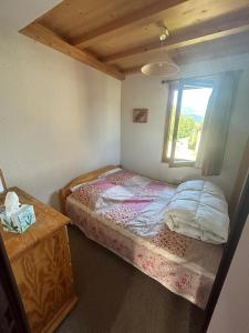 a small bedroom with a bed and a window at Appartement Morzine, deux pièces, mezzanine, 4 personnes in Morzine