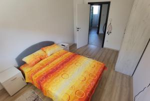 - une chambre avec un lit et une couverture orange dans l'établissement Apartman Banja Koviljaca, à Banja Koviljača