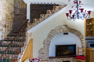 un salon avec un escalier en pierre et un lustre dans l'établissement Palo del Colle Ierva Chiain, Guest House, à Palo del Colle