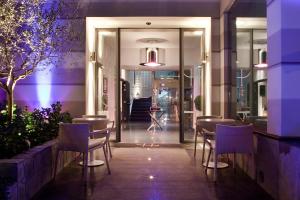 un restaurante con iluminación púrpura, mesas y sillas en LHP Hotel Santa Margherita Palace & SPA, en Santa Margherita Ligure