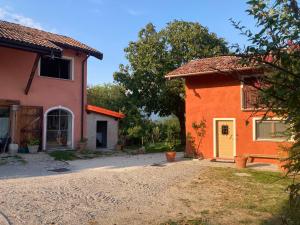 ein orangefarbenes und orangefarbenes Haus neben einem Gebäude in der Unterkunft Antico fienile in Belluno