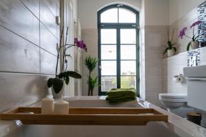 a bathroom with a bath tub with a window at König Albert Residenz nahe BMW , Porsche , DHL und Messe in Leipzig +24 photos