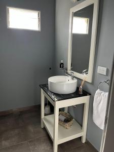 y baño con lavabo y espejo. en Cabañas El Viejo Sauce en Tandil