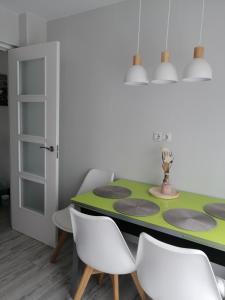 comedor con mesa verde y sillas blancas en Villa Mayki, 
