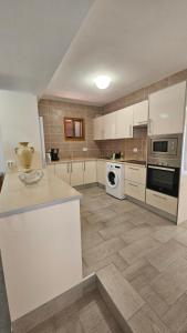 a kitchen with white cabinets and a stove top oven at Callao Sun & Pool in Callao Salvaje