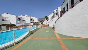 a swimming pool next to a building with a swimming pool at Callao Sun & Pool in Callao Salvaje