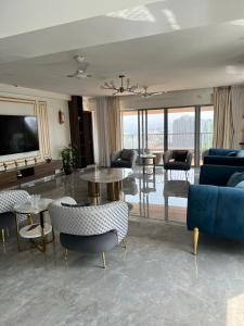 a living room with a couch and a table and chairs at Royal Nest Premium in Pune
