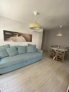 uma sala de estar com um sofá azul e uma mesa em Apartamento Zona Heliópolis Benicasim em Benicàssim