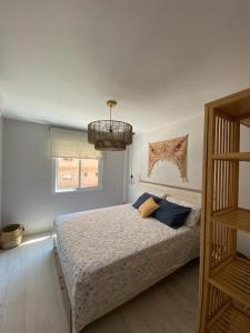 um quarto com uma cama com almofadas azuis em Apartamento Zona Heliópolis Benicasim em Benicàssim