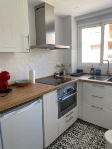 cocina blanca con fregadero y fogones en Apartamento Zona Heliópolis Benicasim, en Benicàssim