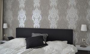 a bedroom with a bed with a black headboard and wallpaper at Kurpark Maisonnette Willingen in Willingen