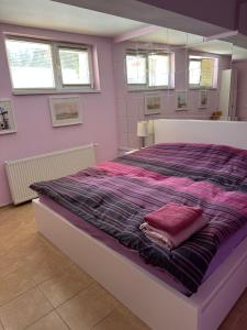 1 dormitorio con 1 cama grande y edredón morado en Casa Portocalie, en Cisnădioara