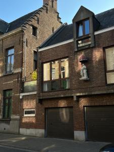 un edificio di mattoni con una statua sopra di Giorgio ad Anversa