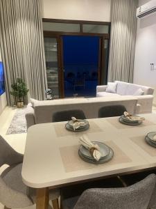 uma sala de estar com uma mesa e um sofá em Escape Villa em As Sifah