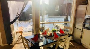 a table with red napkins on it in a kitchen with a window at Topp moderne familiehytte på Beitostølen (bygget i 2019) in Beitostøl