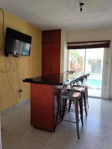 a kitchen with a table and chairs and a tv at Casa /alberca, chapoteadero, mirador, wifi in Veracruz